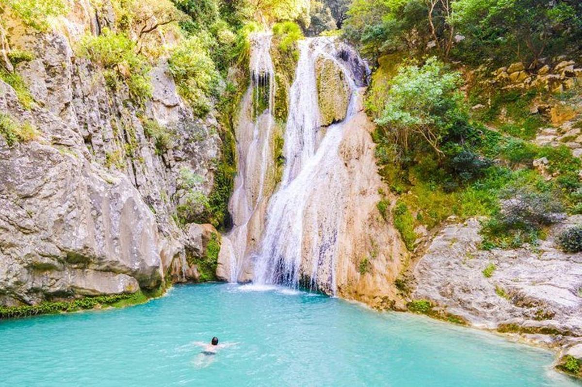 una persona che nuota in una piscina di fronte a una cascata