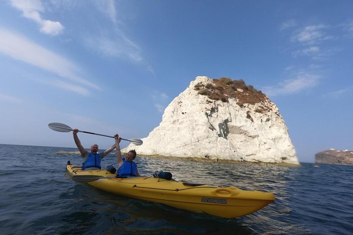 due persone in un kayak giallo nell'oceano con una roccia