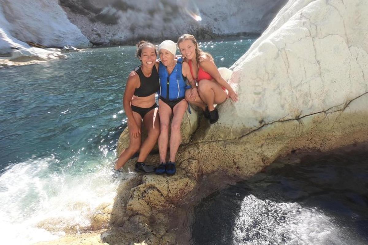 tre donne sedute su una roccia nell'acqua