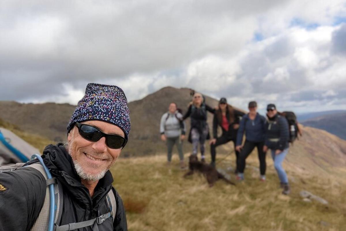 a group of people walking on a hill with a dog