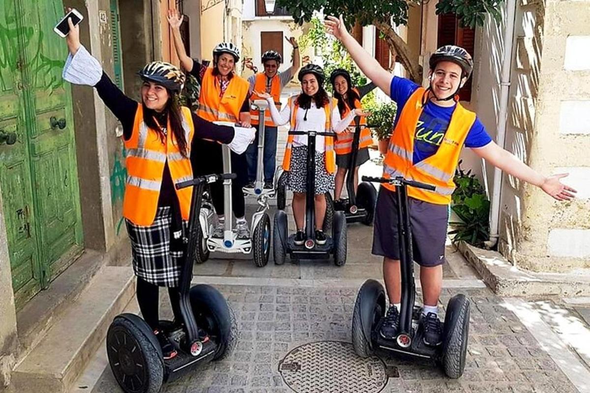 Hópur fólks í appelsínugulum vestum á Segway-hjólum