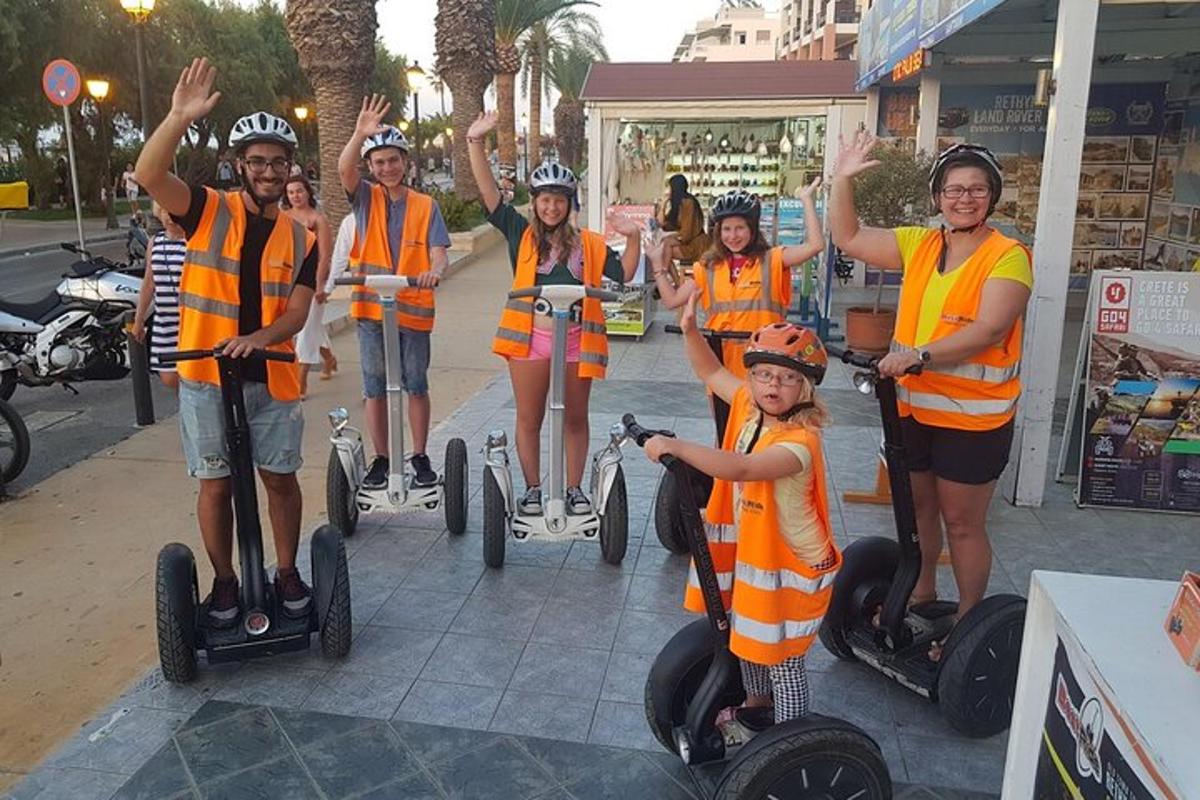 un gruppo di persone con gilet arancioni sui segway