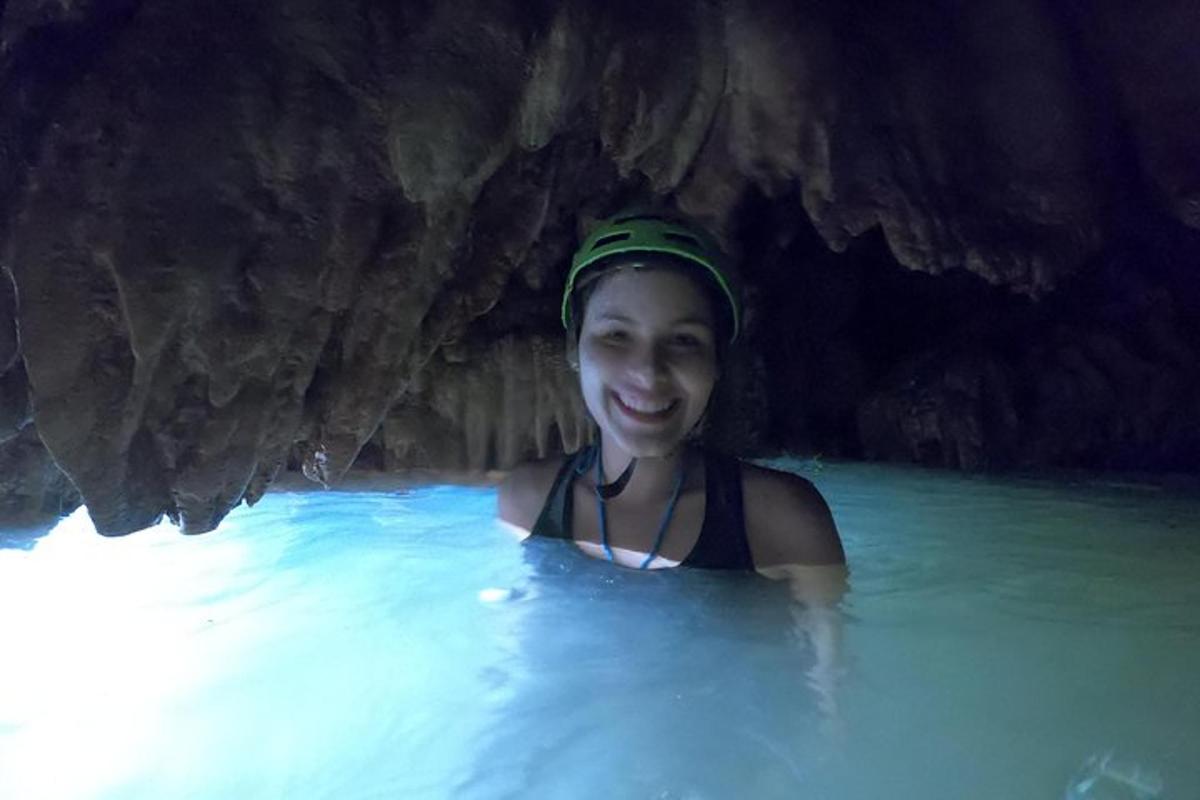 a woman is swimming in a cave in the water