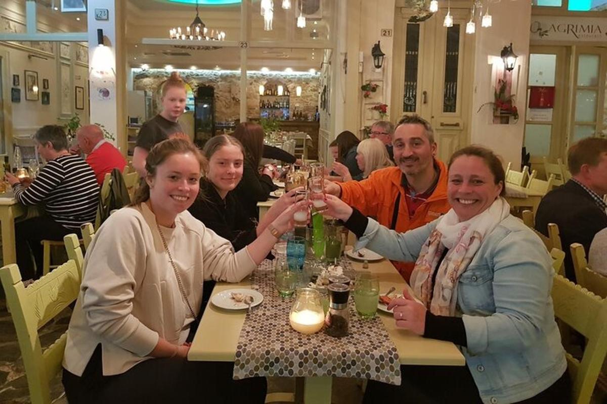un gruppo di persone sedute a un tavolo che bevono champagne