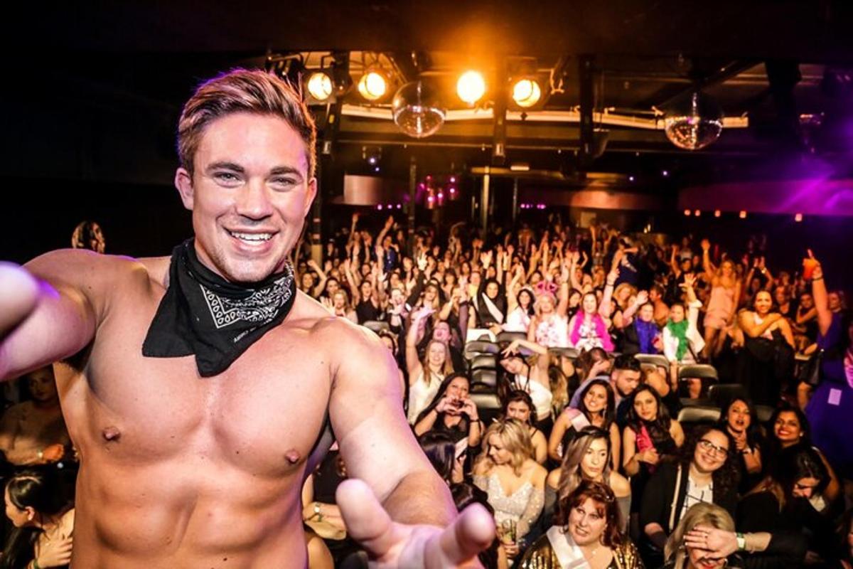 a shirtless man in front of a crowd of people