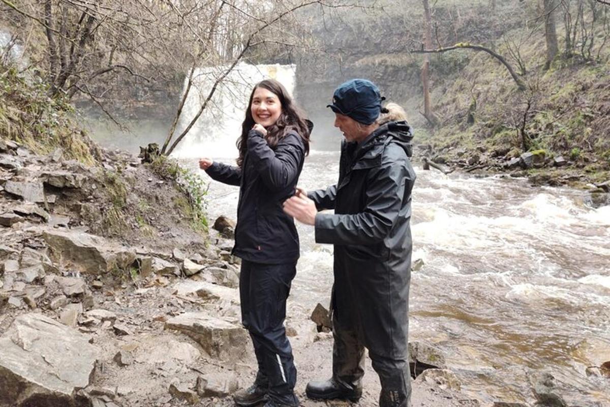 a man and a woman standing next to a river