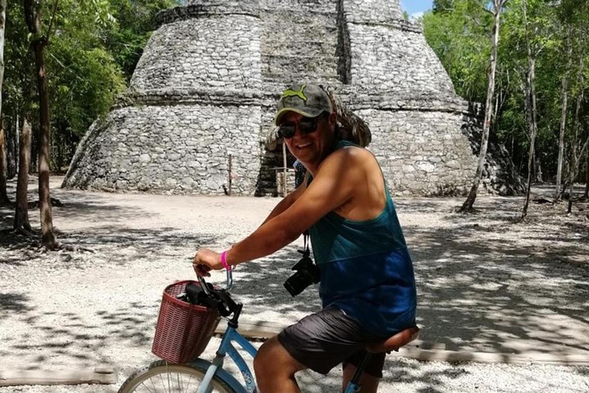 muž jedoucí na kole před pyramidou