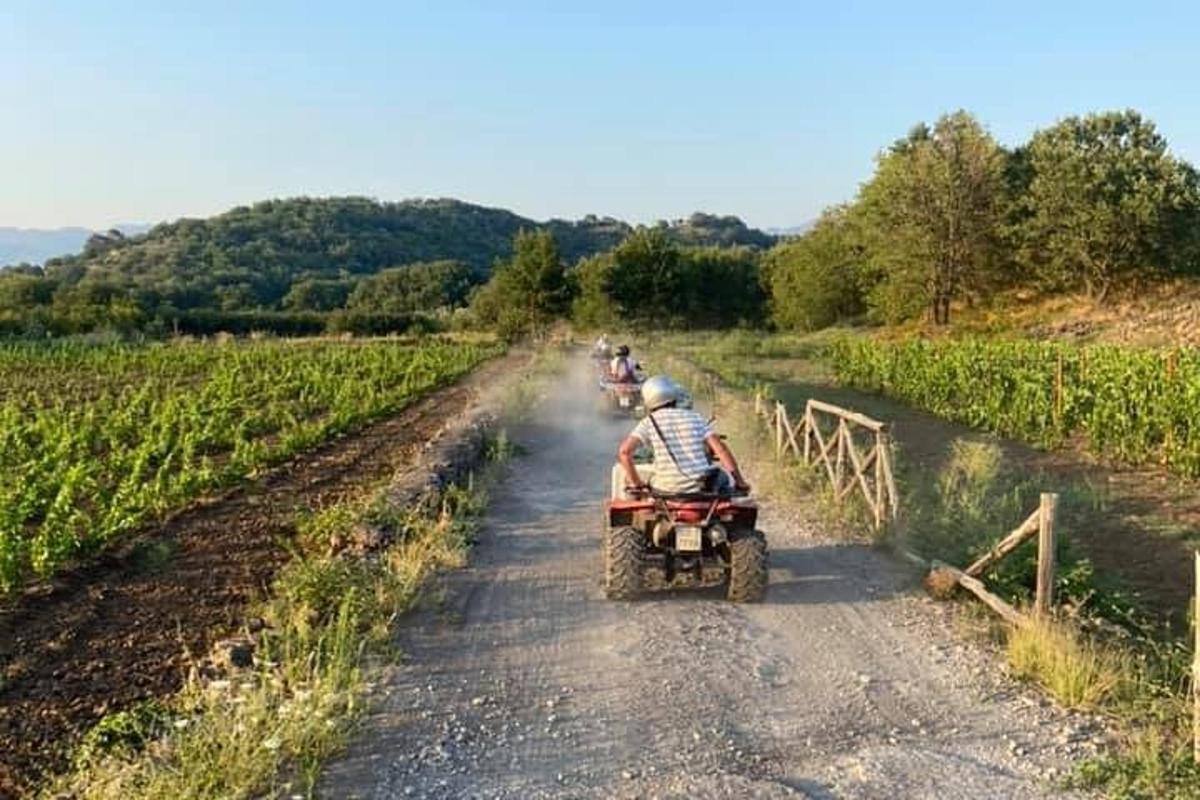 cilvēku grupa, kas brauc ar kvadraciklu pa zemes ceļu