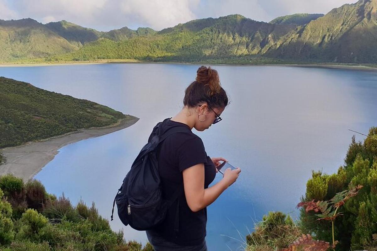 kona með bakpoka að horfa á vatn