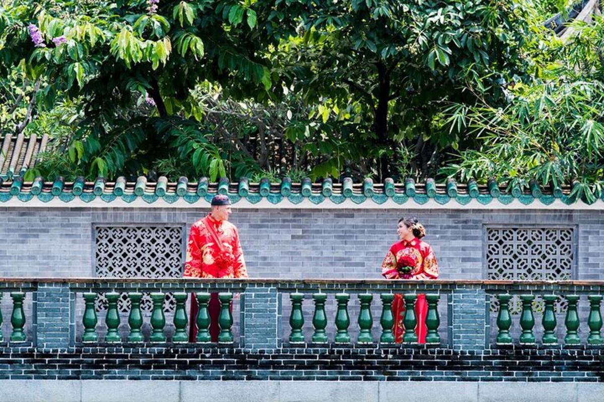 two people in red uniforms standing on a fence