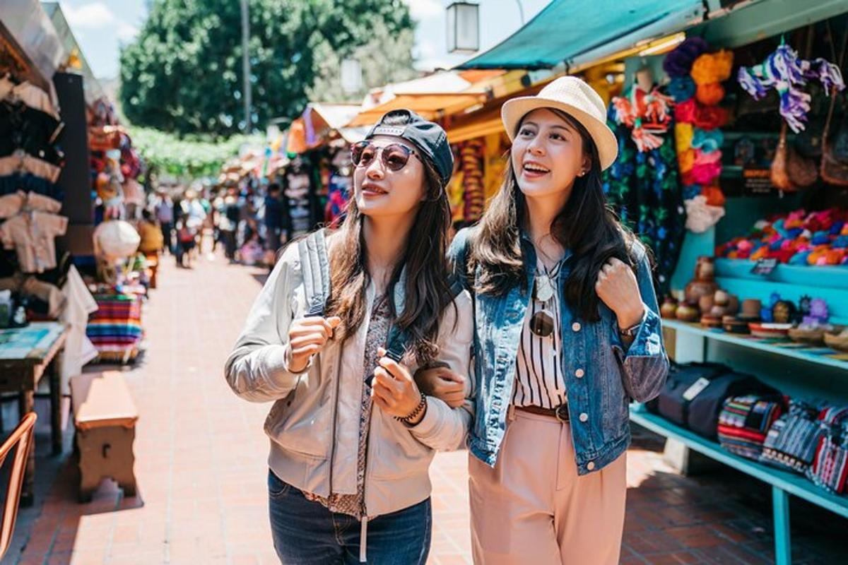 two women walking down a street in a market