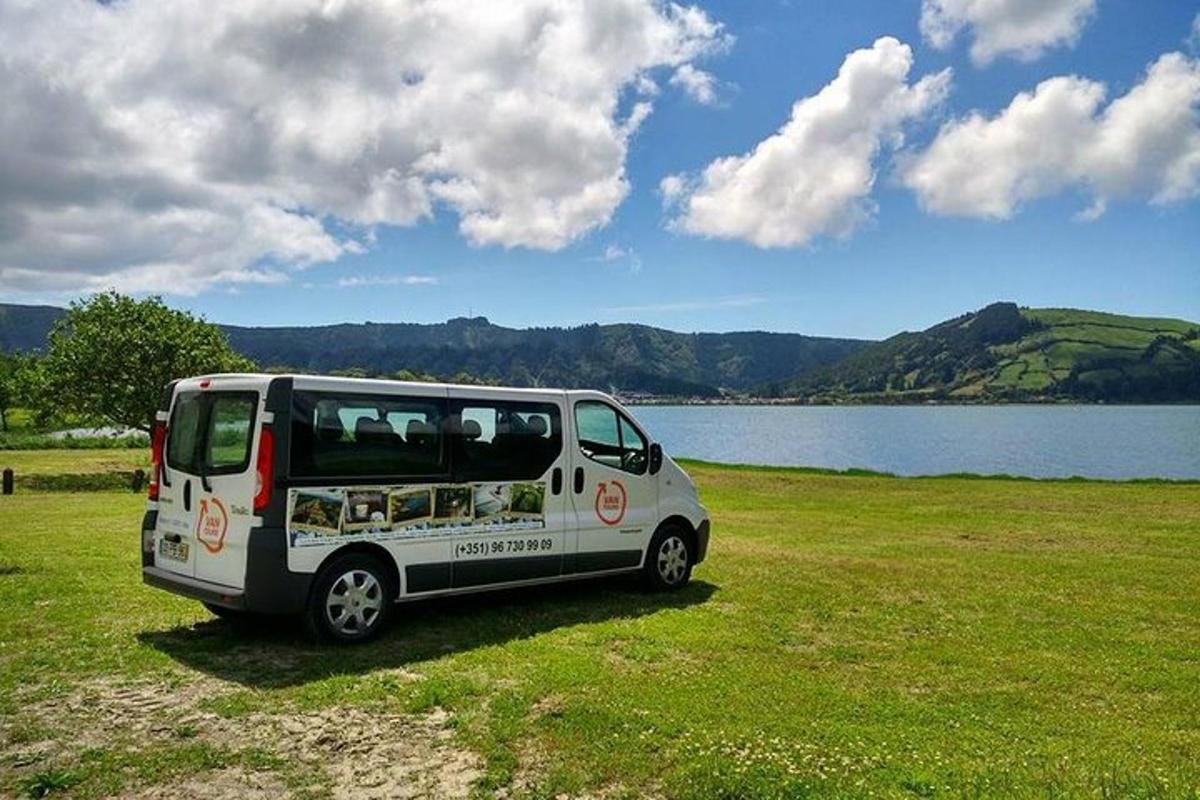 una furgoneta blanca aparcada en un camp al costat d'un llac