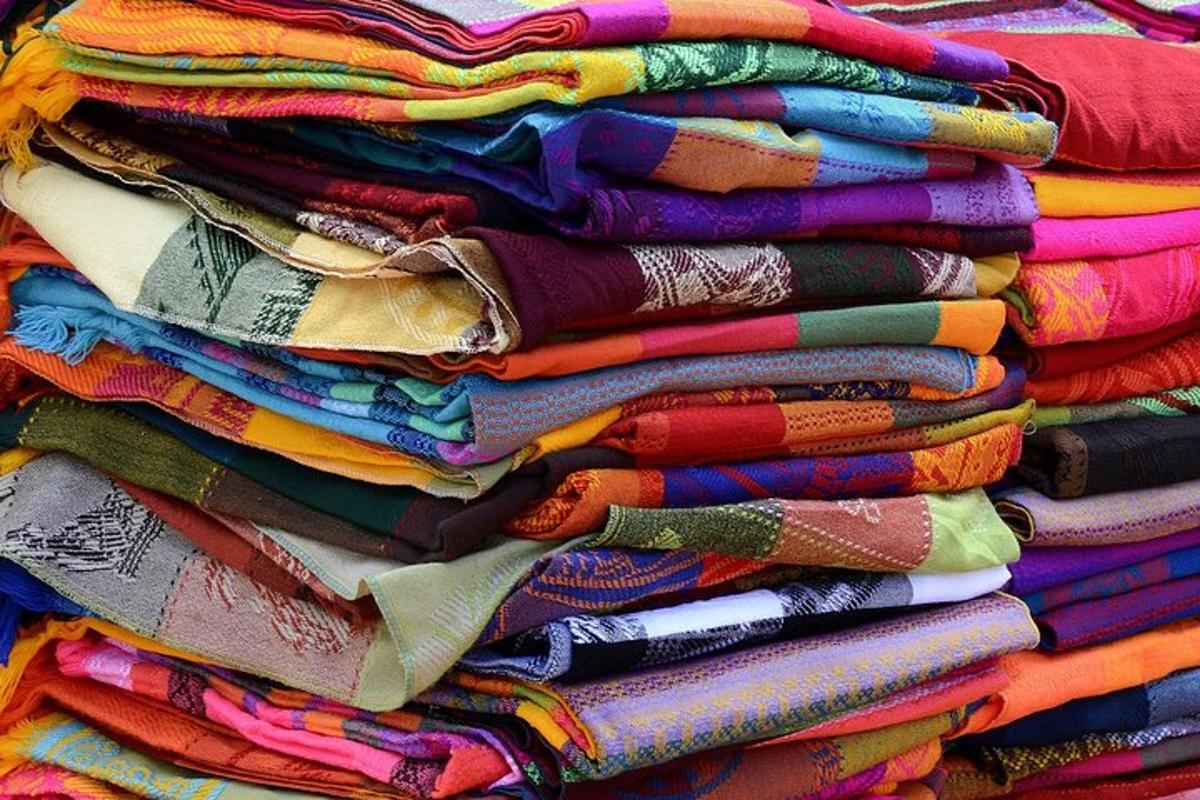 a pile of different colored shirts stacked on top of each other