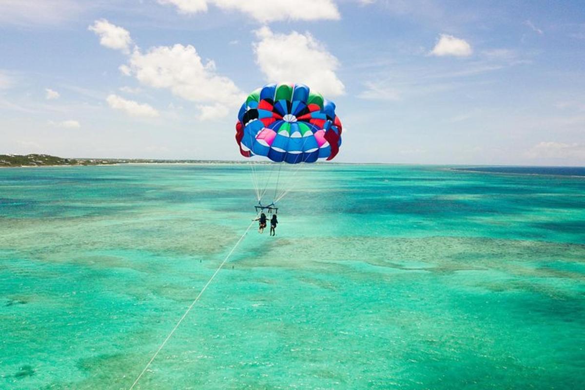 a person flying a parachute over the water