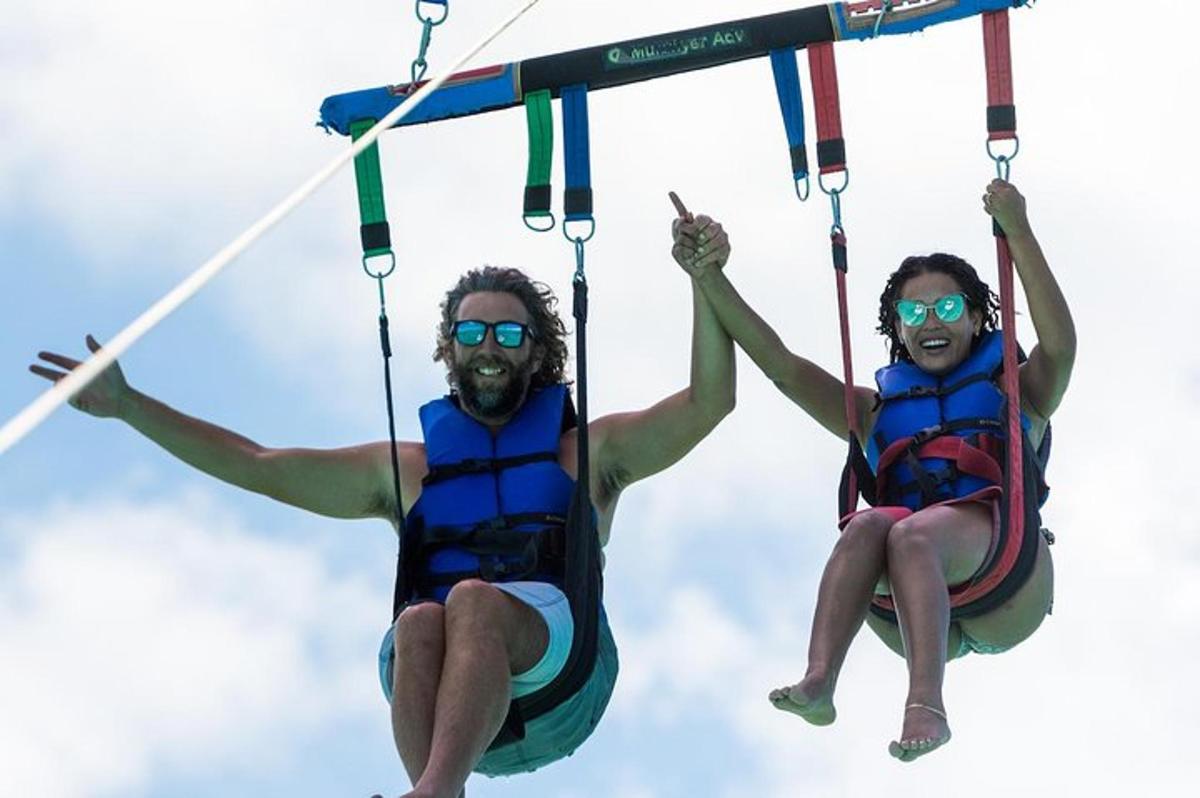 two men are riding on a zip line in the air