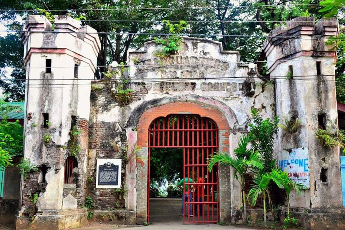 an old stone building with a red gate