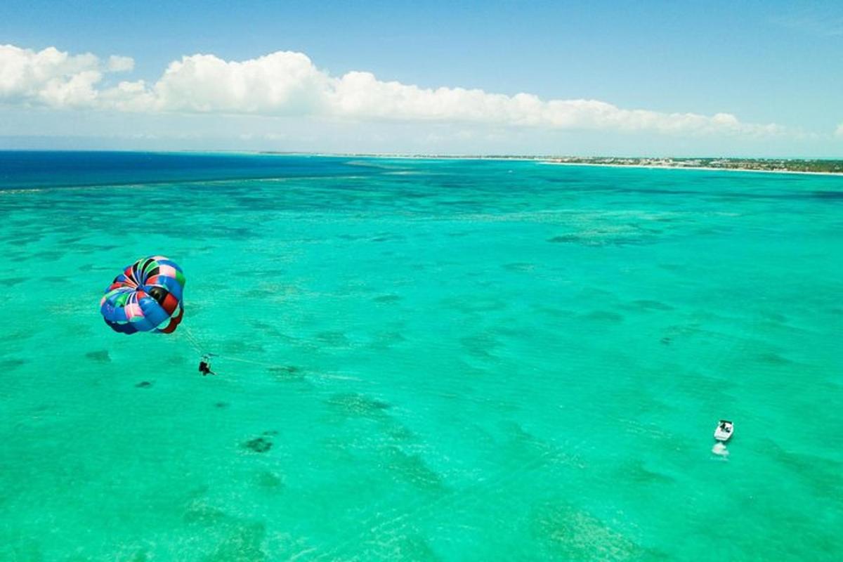 a person in the ocean with a parachute in the water