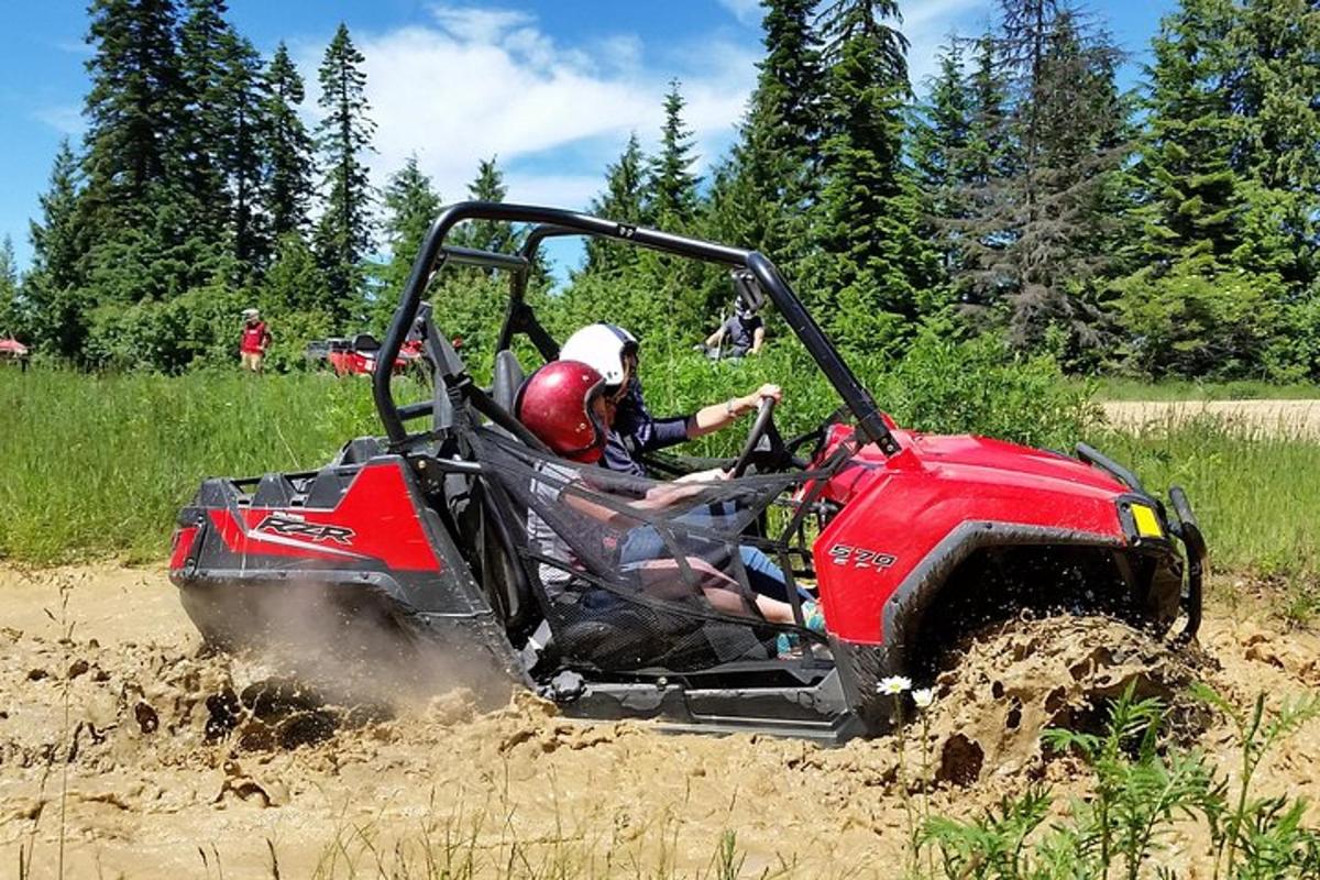 a person riding in a atv in the mud