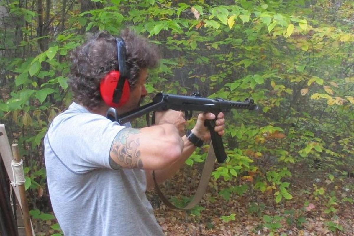 um homem segurando uma arma com fones de ouvido na cabeça