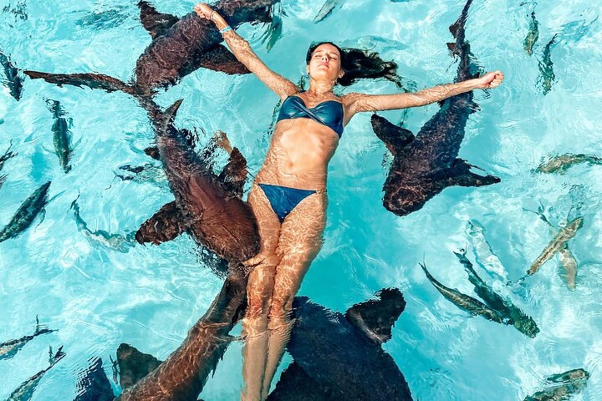 a woman floating in a pool of water with fish