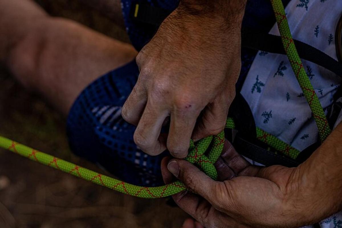 um homem segurando uma corda verde com a mão