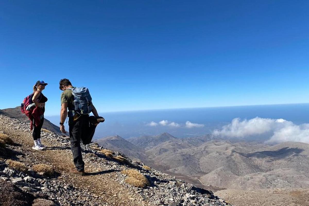 tveir menn standa á fjallstindi