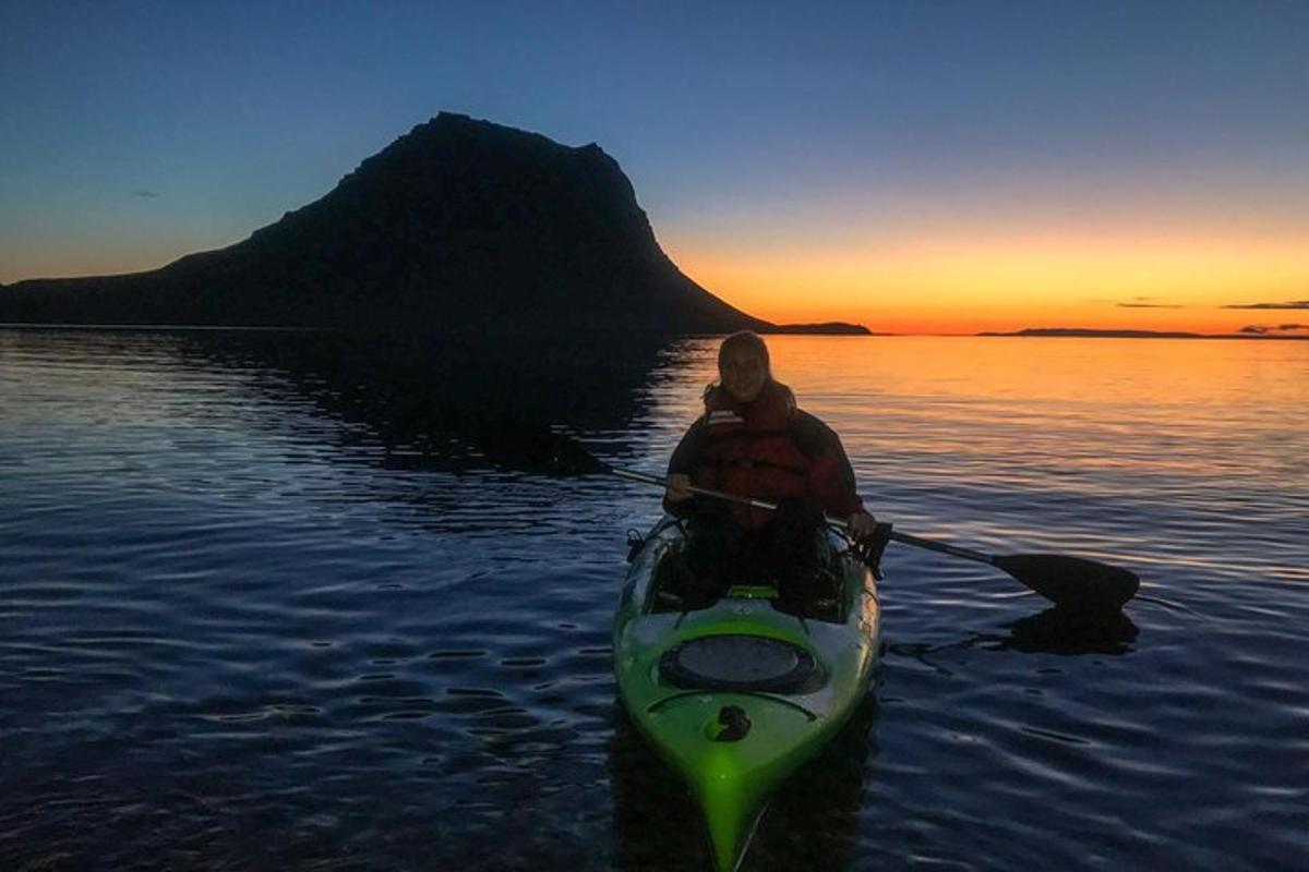 a man in a kayak on the water at sunset