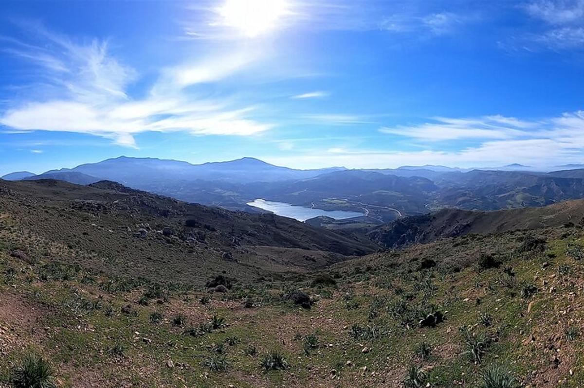 uma vista de uma montanha com um lago ao longe
