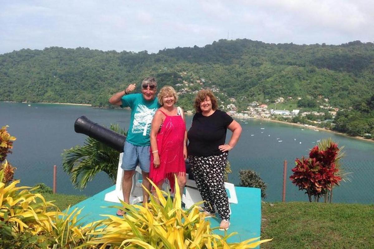 a group of three people posing for a picture in front of a lake