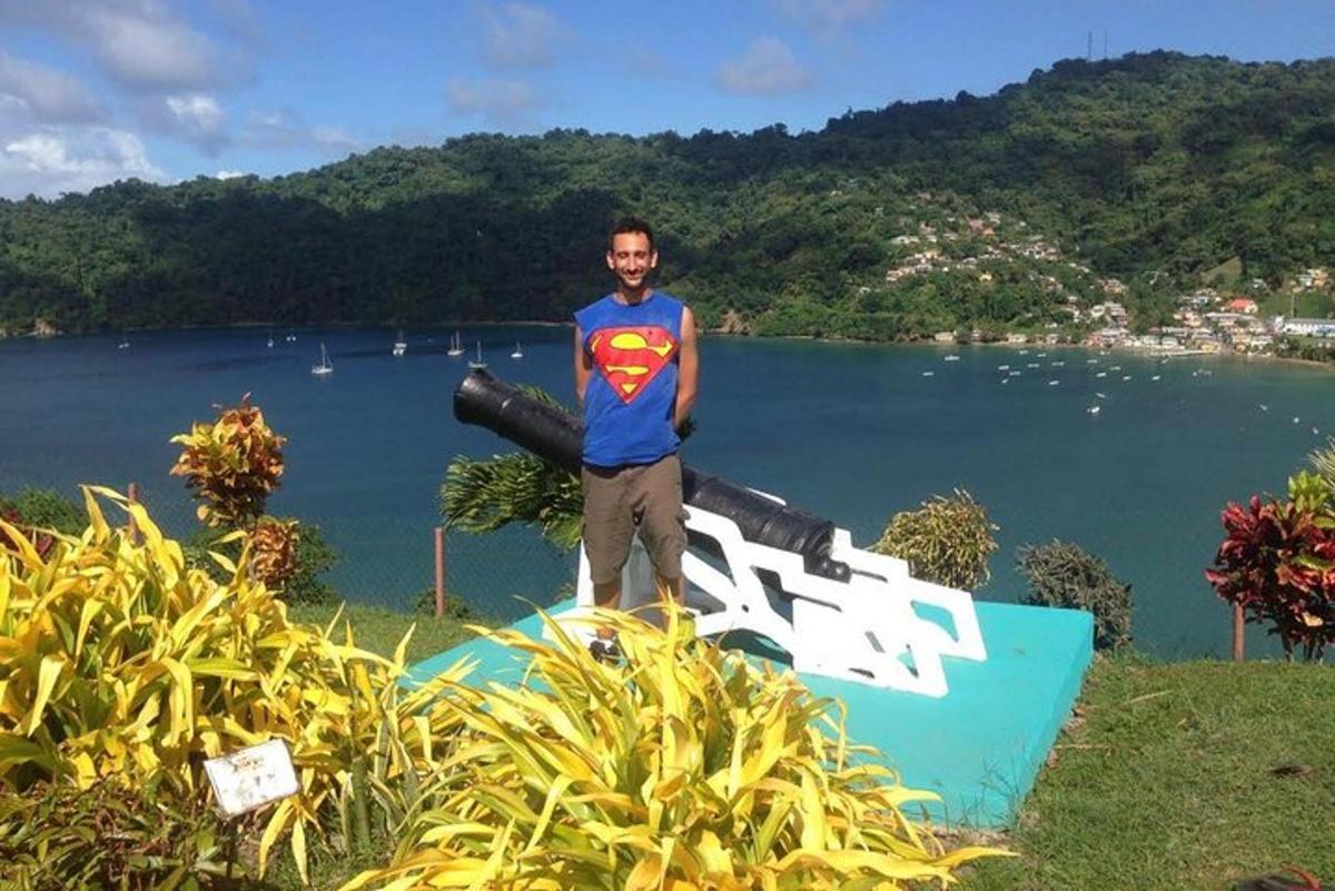 a man standing on a sign in front of a body of water