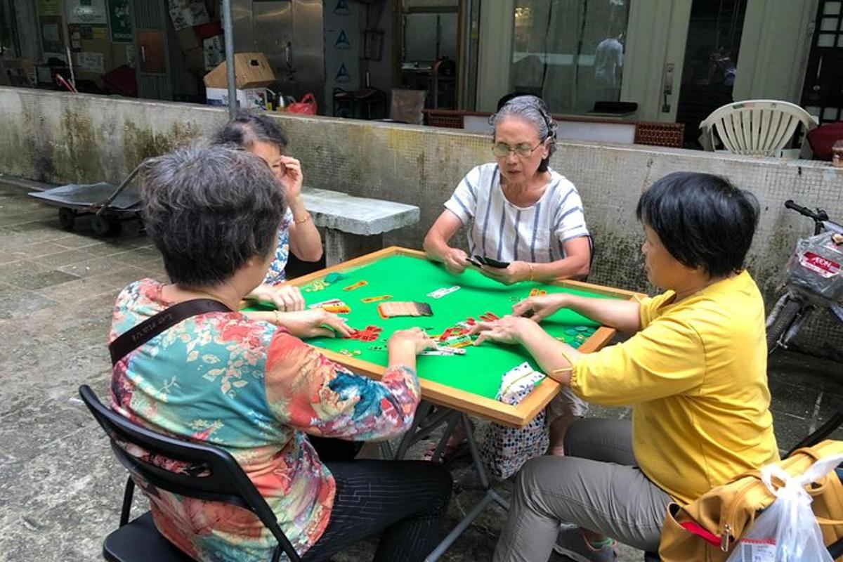 grupa ljudi sjedi oko stola i igra poker