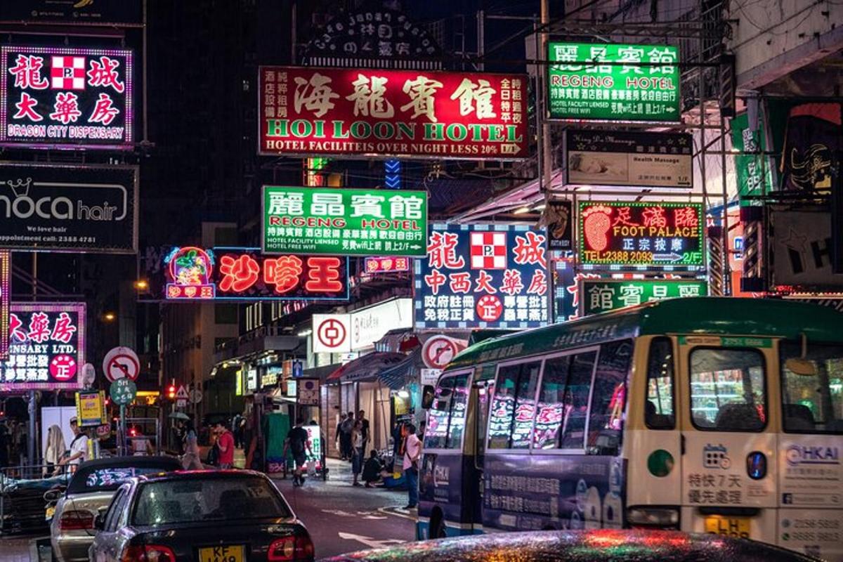 isang abalang kalye ng lungsod sa gabi na may mga neon sign