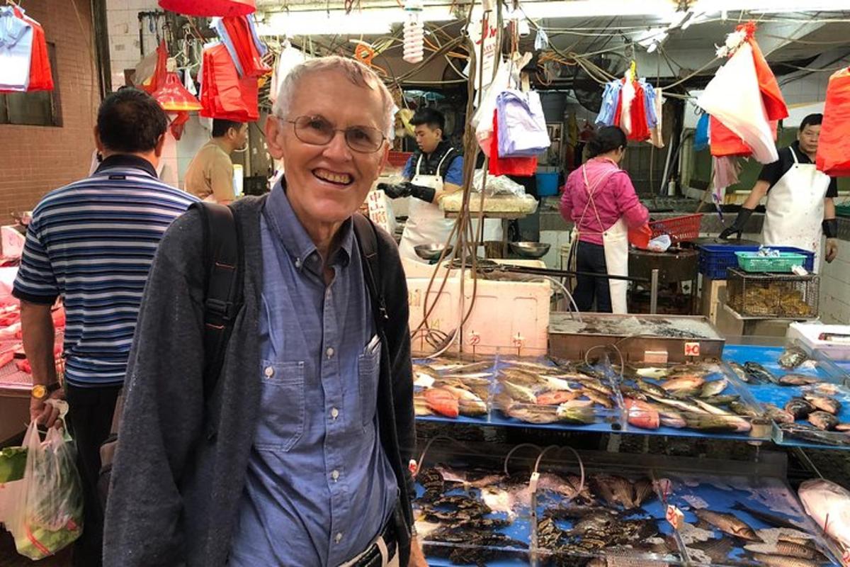 a man standing in front of a market with food