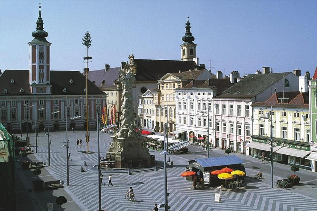 a city square with a statue in front of buildings