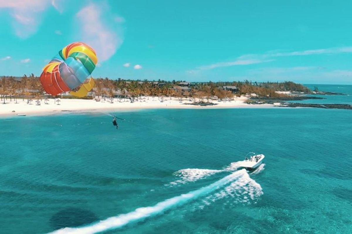 una persona che fa kitesurf nell'oceano con una spiaggia
