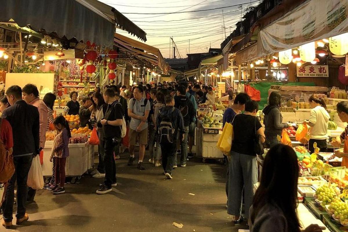 una folla di persone in piedi in un mercato aperto