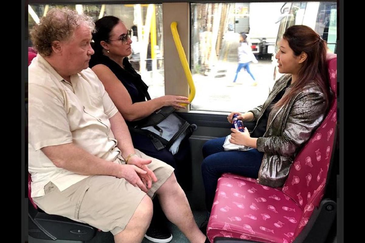 tre persone sedute sul retro di un autobus