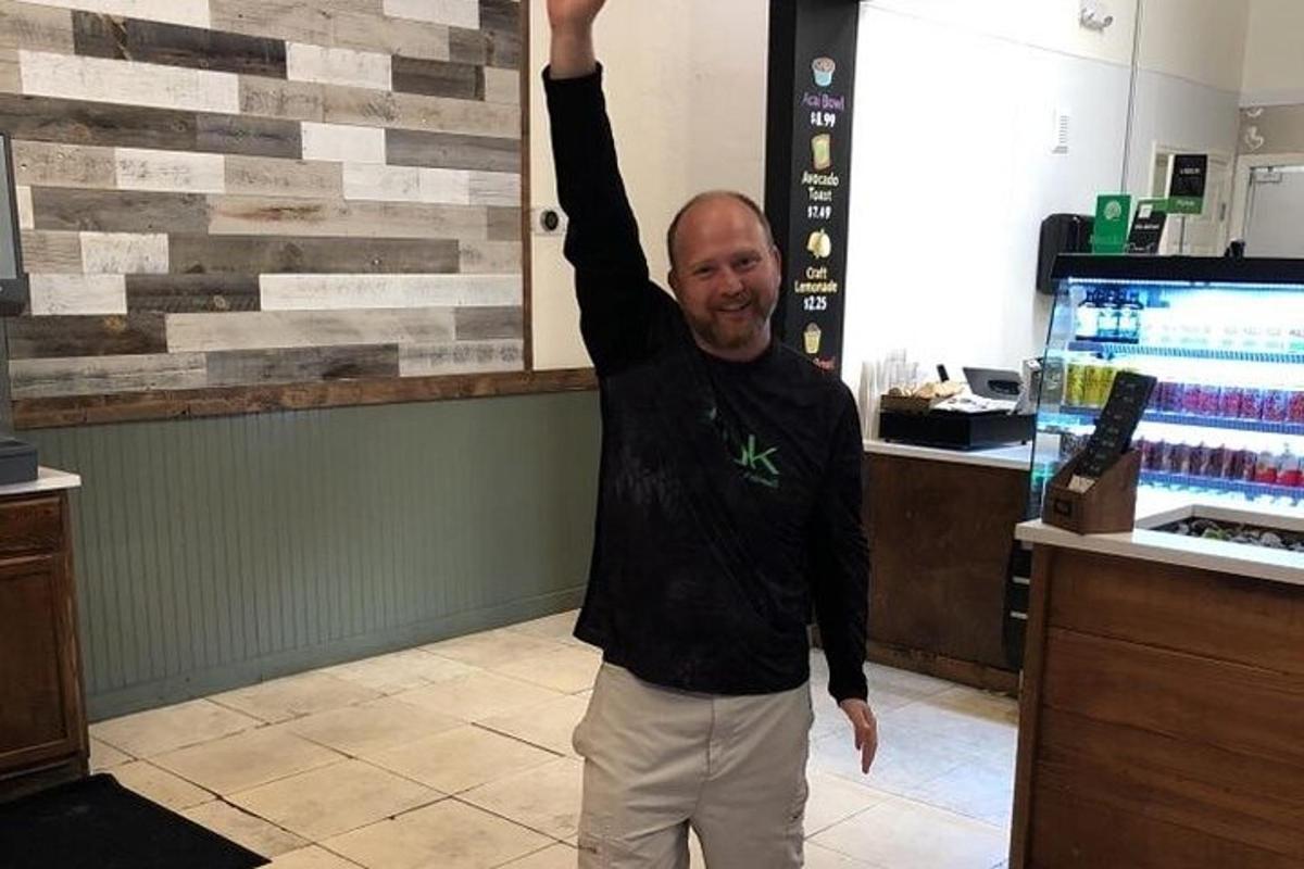 a man standing in a store with his arm in the air