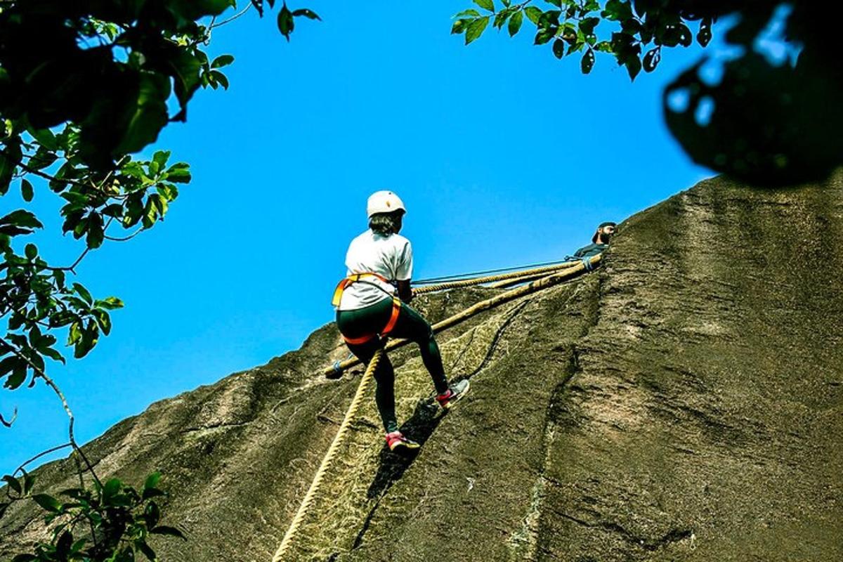 một người đang đứng trên đỉnh một tảng đá