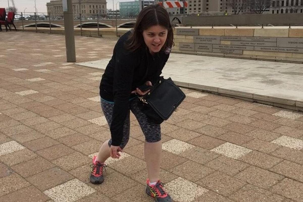 a young girl walking on a sidewalk with a purse