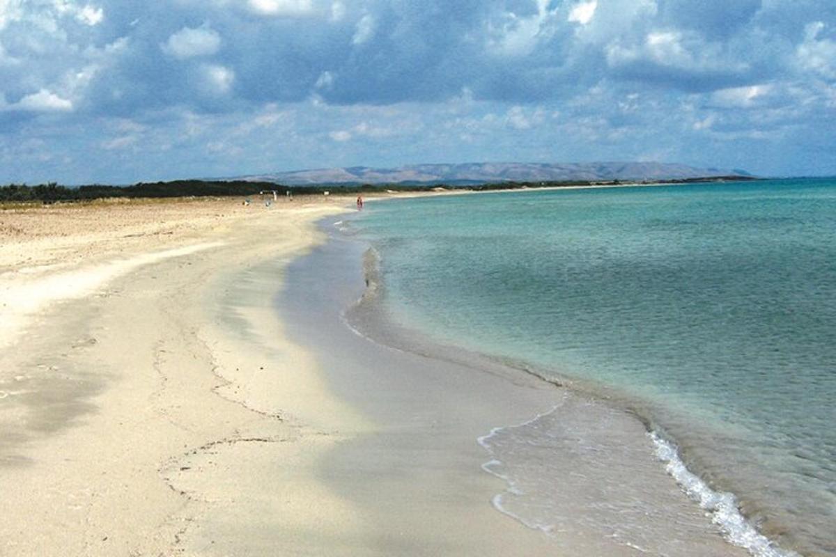 μια αμμώδης παραλία με τον ωκεανό και τον ουρανό