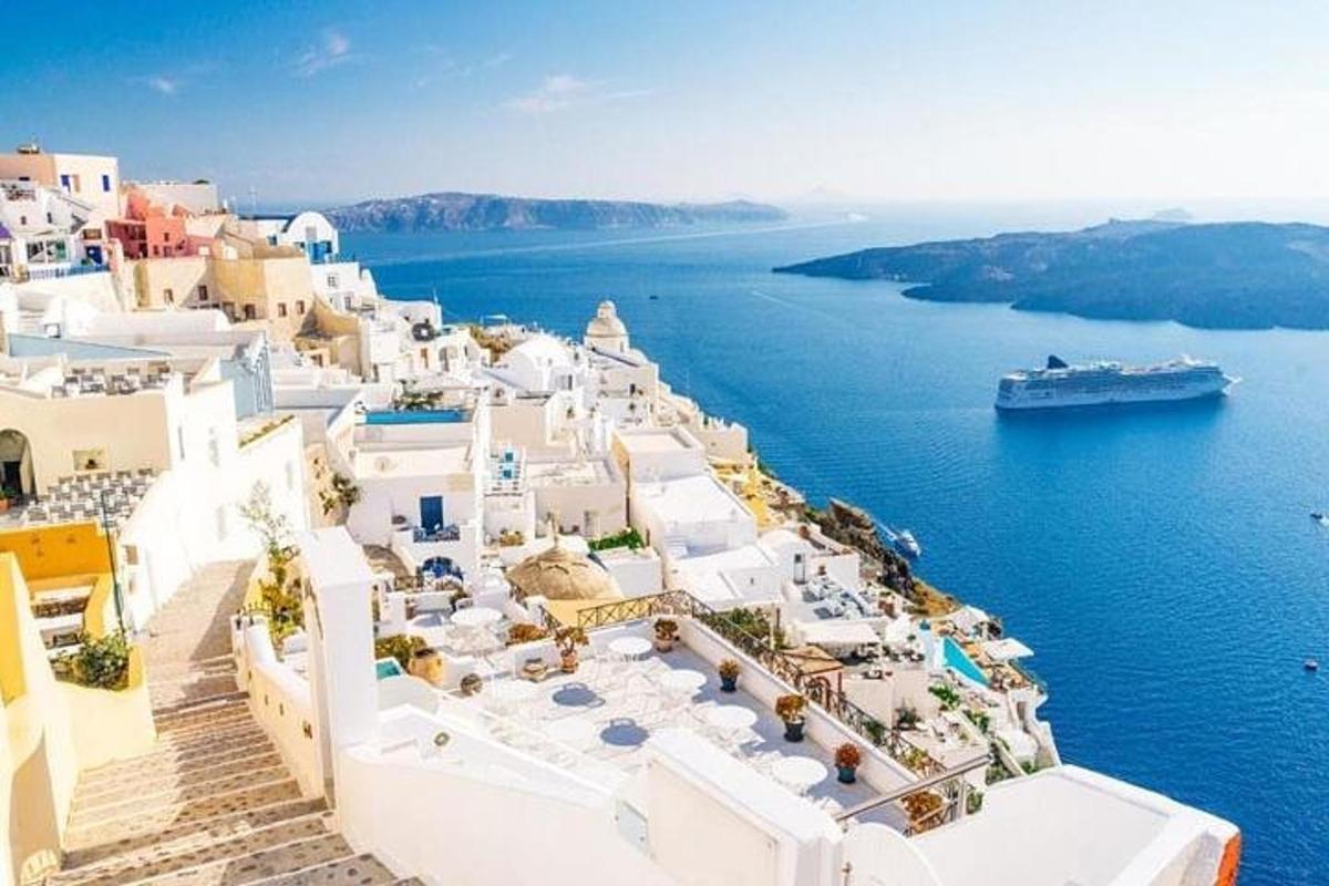 an island with white buildings and a cruise ship in the water