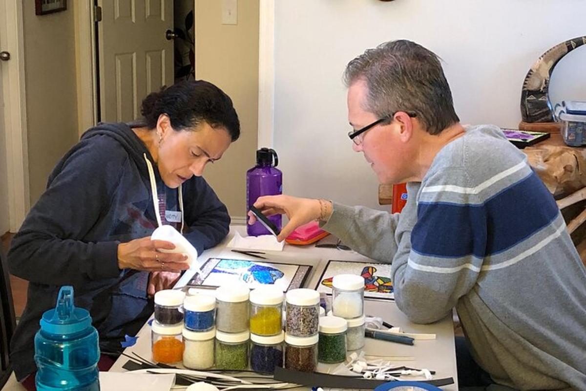 two people standing at a table with paint supplies