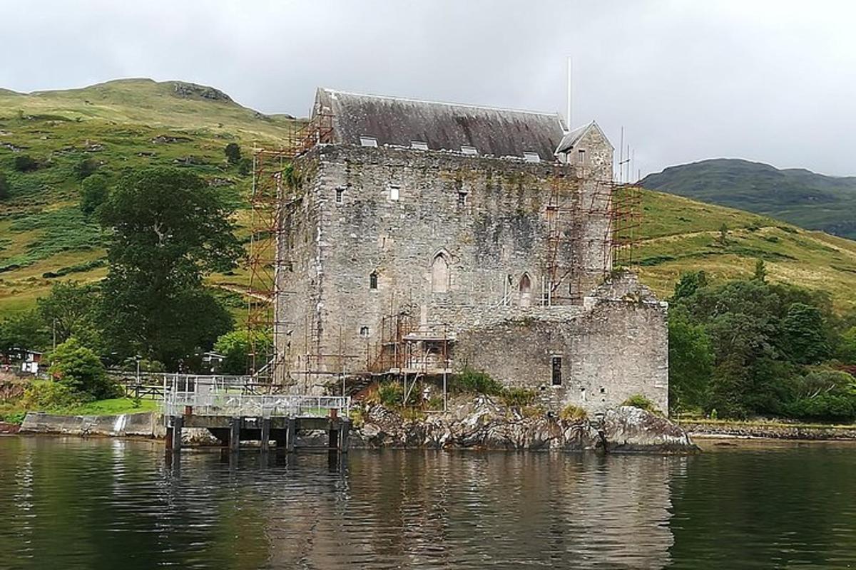 an old building sitting on the edge of a body of water