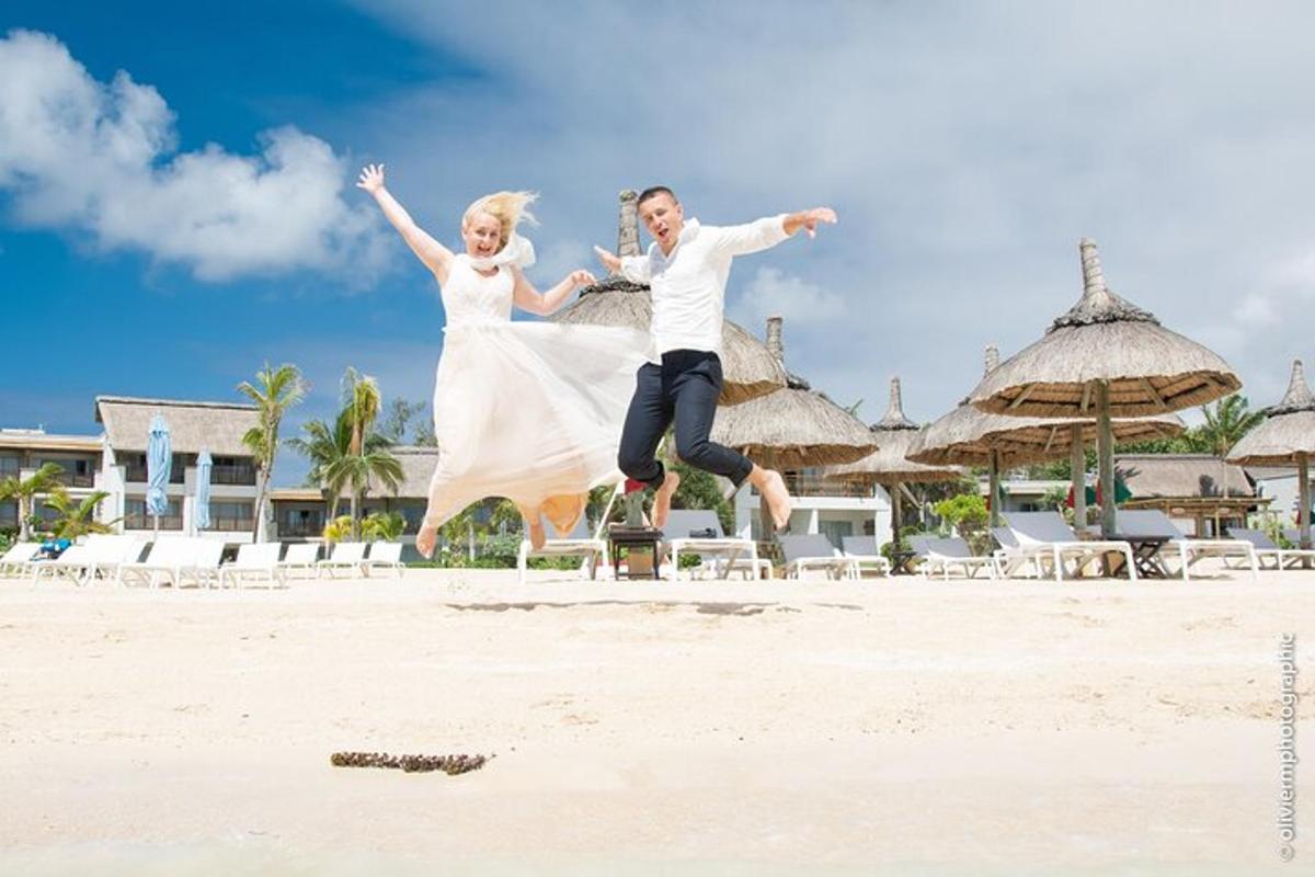 una sposa e uno sposo che saltano in aria sulla spiaggia