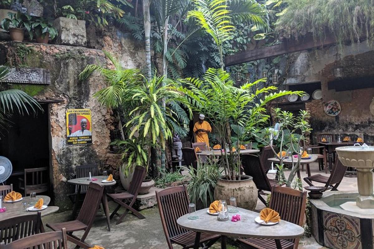 Un restaurante con mesas, sillas y plantas.