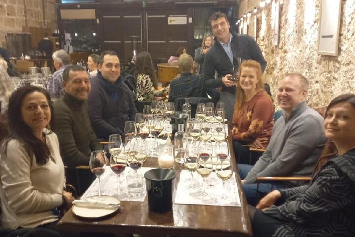un grup de persones assegudes a una taula amb copes de vi