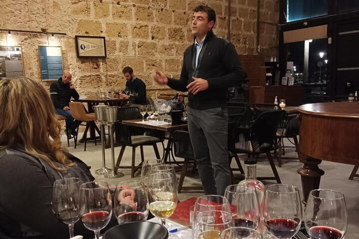 un home dret davant d'una taula amb copes de vi