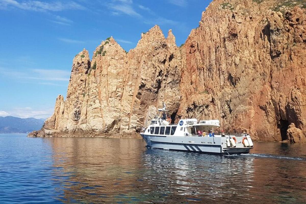 a boat in the water next to a rock formation