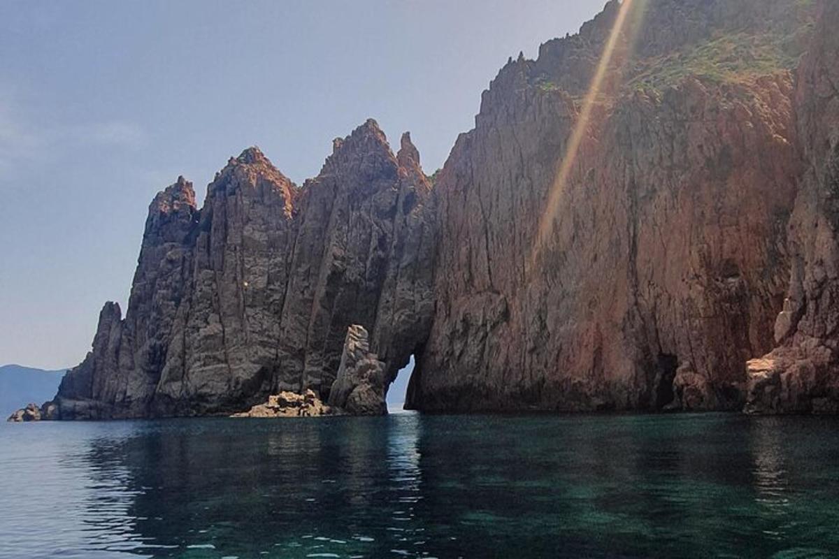 a rainbow over the water with a mountain